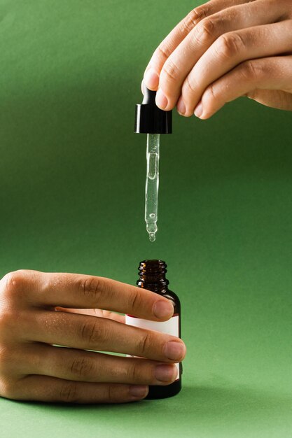 Pipetta con olio di cannabidiolo CBD in mano Olio di CBD dalla pianta di cannabis per aiutare a ridurre l'ansia del dolore e i disturbi del sonno