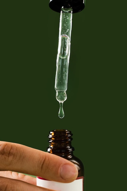 Pipetta con olio di cannabidiolo CBD in mano primo piano Olio di CBD dalla pianta di cannabis per aiutare a ridurre l'ansia del dolore e i disturbi del sonno