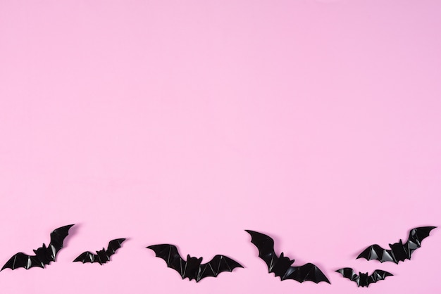 Pipistrelli di carta neri che sorvolano il rosa