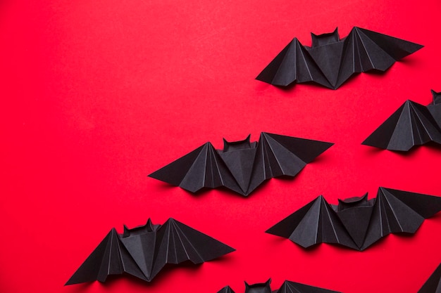 Pipistrelli di Halloween fatti di carta su sfondo rosso