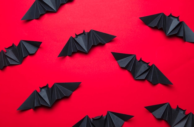 Pipistrelli di Halloween fatti di carta su sfondo rosso