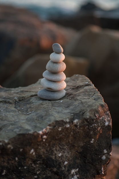 Piramide di pietra Zen in riva al mare al tramonto