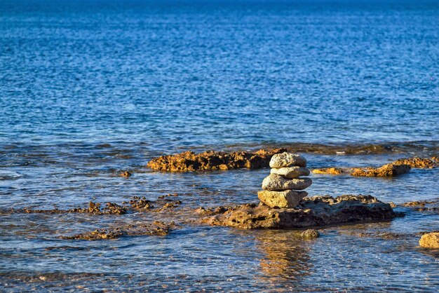 Piramide di pietre sull'acqua di mare e uno spazio vuoto per il testo