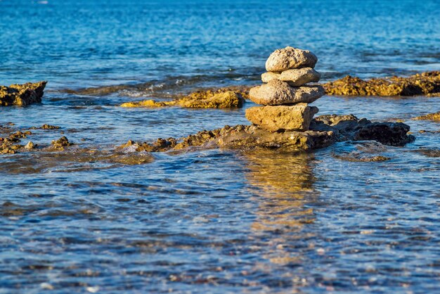 Piramide di pietre sull'acqua di mare e uno spazio vuoto per il testo