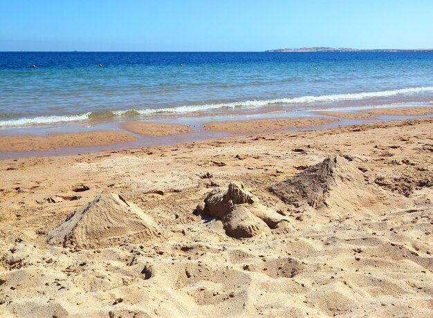 Piramidi egizie e sfinge dalla sabbia sulla spiaggia