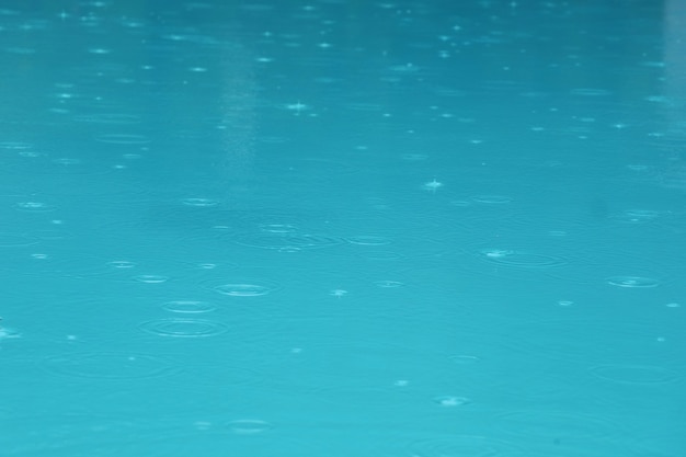 Piscina con gocce d'acqua e riflesso nell'acqua in una giornata piovosa. Sport e concetto di sfondo.