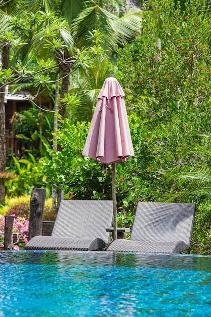 Piscina con lettini e ombrelloni rilassanti in giardino tropicale