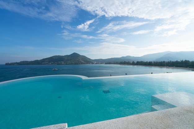 Piscina con scala in cima all'edificio sul tetto con vista sul mare tropicale, lussuosa villa sulla spiaggia con piscina vista mare dal design moderno, vacanze estive e concetto di sfondo di viaggio.