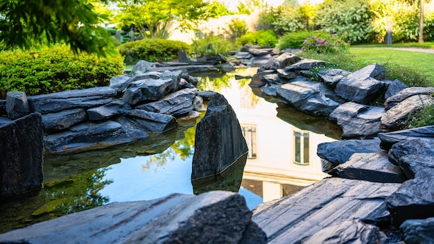 Piscina d'acqua dolce tra pietre scure in un giardino in stile giapponese