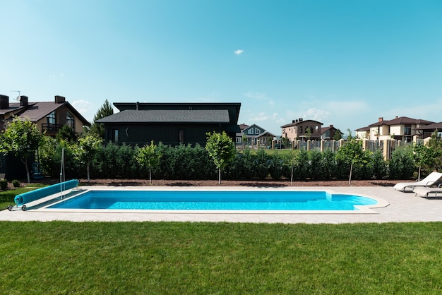 Piscina di una casa di lusso con lettini Rilassatevi nel cortile di una casa di campagna