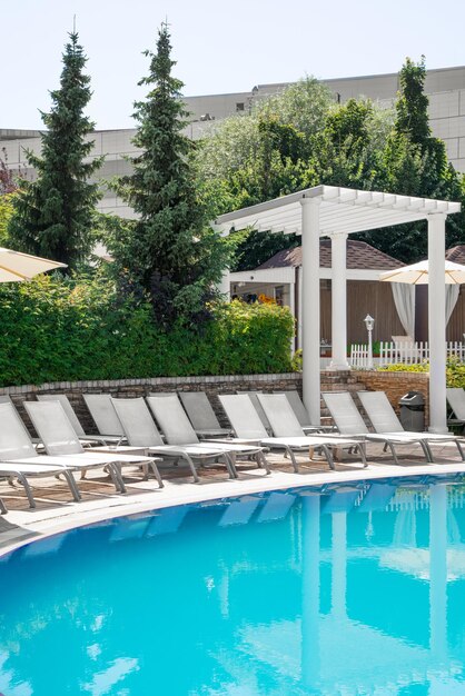 Piscina e lettino bianco con lettino da spiaggia moderno sul ponte della piscina