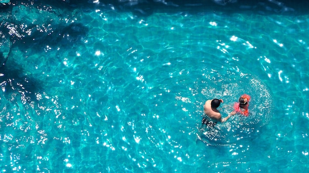 Piscina e padre e figlia e giocare insieme e momento di felicità e vista dall'alto.