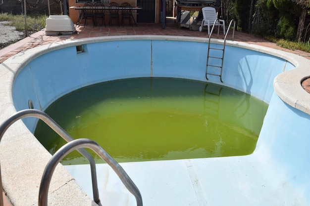 Piscina in cemento semicircolare inquinata non trattata con acqua stagnante non filtrata da pulire