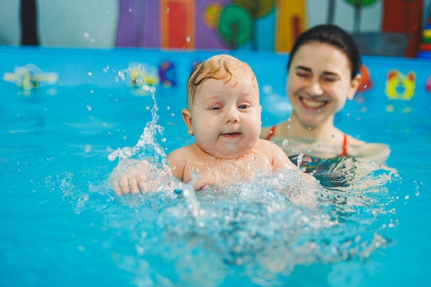 Piscina per l'addestramento dei neonati a nuotare Bambino che nuota in piscina Insegnare a un neonato a nuotare in piscina con un allenatore