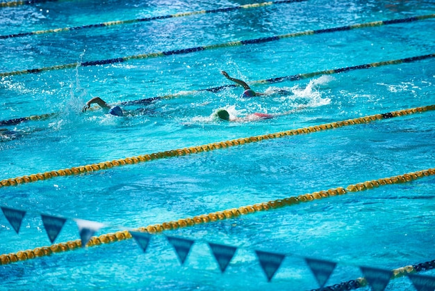 Piscina sportiva olimpionica con persone irriconoscibili che nuotano nell'acqua.