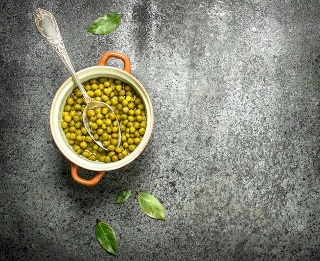 Piselli marinati in una ciotola sul tavolo rustico.