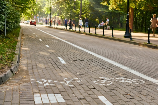 Pista ciclabile a due vie e auto di traffico, tracciato di marcatura della pista ciclabile, segno di bicicletta dipinto di bianco su strada su strada. Simbolo della bici da strada. Pedala in bicicletta, in bicicletta, in bicicletta, su ruote e concetto di stile di vita sano