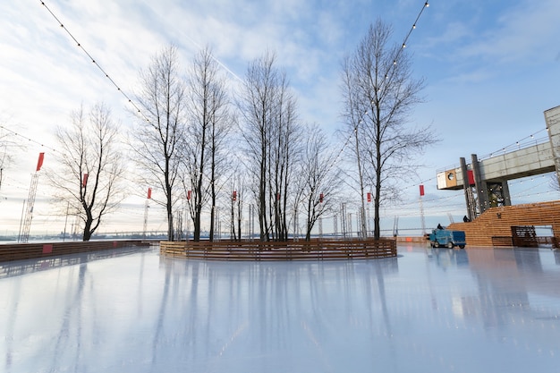 Pista di pattinaggio vuota con oasi sugli alberi e un rullo in una bella giornata invernale in Russia.