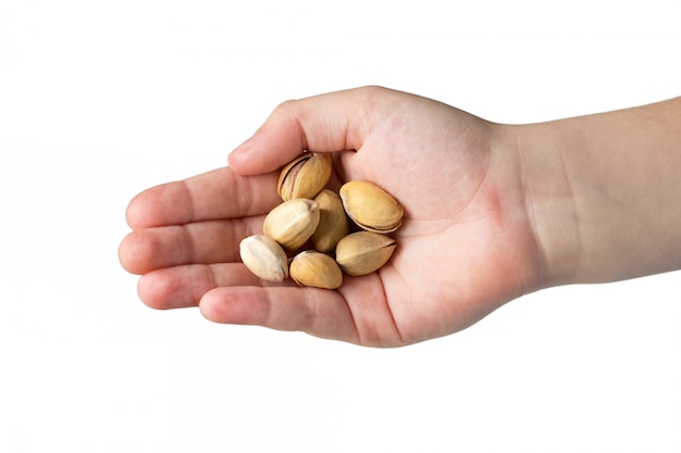 Pistacchi arrostiti nelle mani del bambino isolato su sfondo bianco.