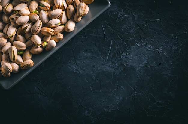 Pistacchi in un piatto rettangolare grigio su un tavolo scuro