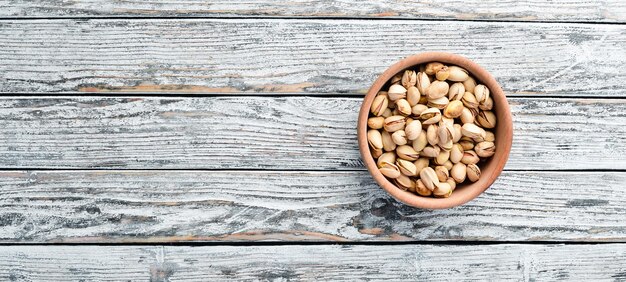 Pistacchi su fondo di legno bianco Vista dall'alto Spazio libero per il testo