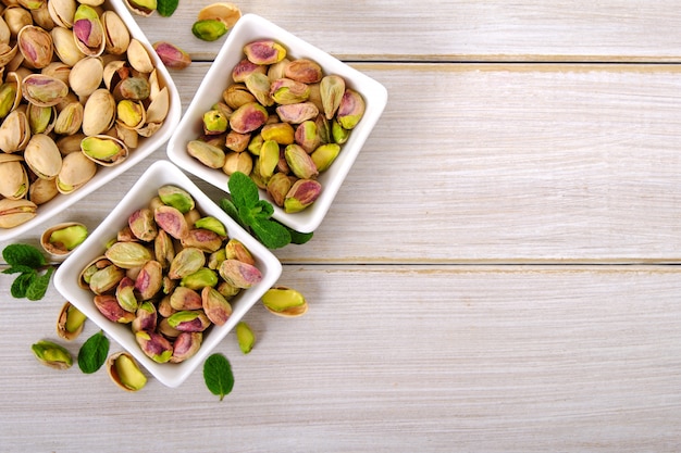 Pistacchi su fondo di legno bianco