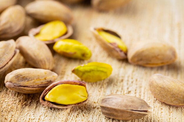 Pistacchi tostati. Pistacchi fritti e salati su fondo di legno. Avvicinamento