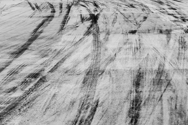 Piste astratte della gomma del nero del fondo sulla strada del cemento, segni della gomma sulla strada del cemento.