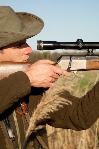 Pistola da caccia e uomo in un safari in Africa in campo per sparare agli animali durante le vacanze nella natura