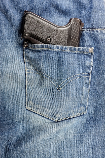 Pistola nella tasca dei jeans.