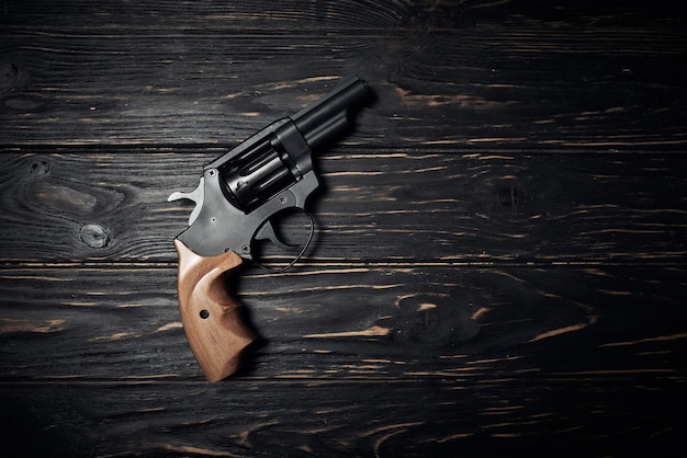 Pistola revolver nera su fondo di legno scuro