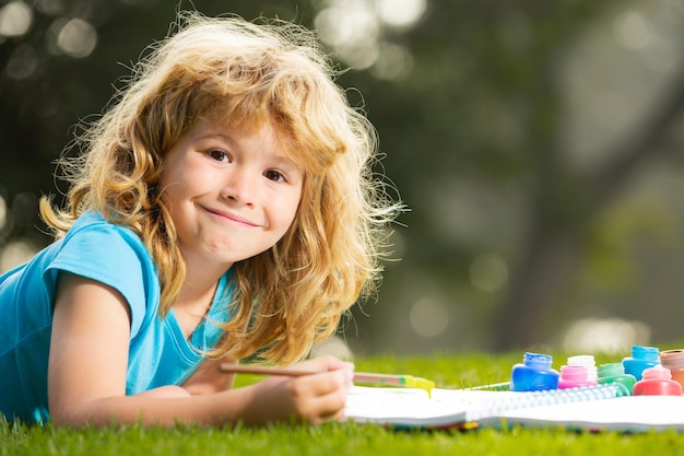 Pittore artista ragazzo di talento felice Ragazzo bambino godendo di arte e artigianato disegno nel cortile o nel parco primaverile Bambini che disegnano disegnare con le matite all'aperto