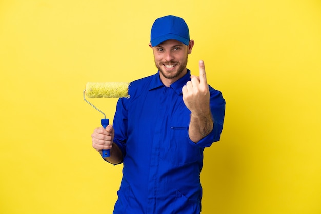 Pittore brasiliano uomo isolato su sfondo giallo facendo gesto venuta