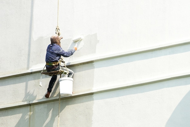 pittore che appende su edificio bianco