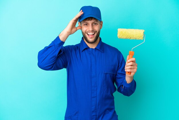 Pittore uomo caucasico isolato su sfondo blu con espressione sorpresa