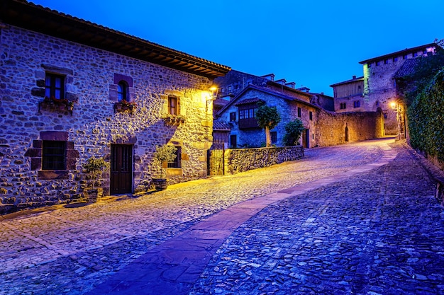 Pittoresca strada cittadina medievale con strada acciottolata e campanile della chiesa al tramonto. Santillana del Mar.