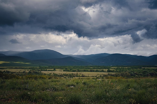 Pittoresca valle verde tra le montagne prima di una tempesta