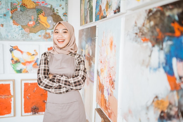 Pittrice musulmana che dipinge su tela nel suo laboratorio