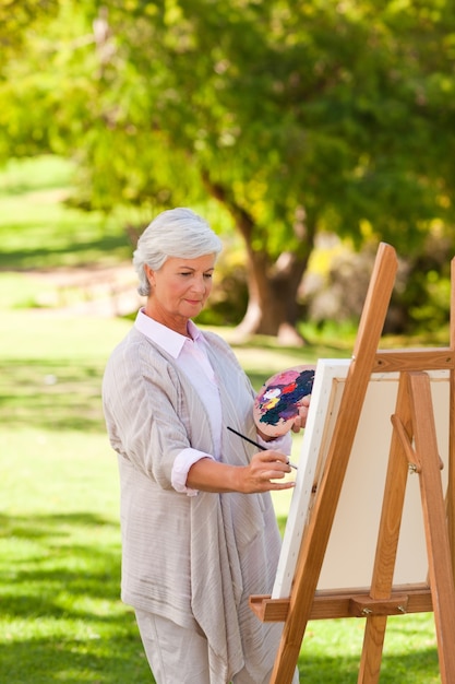 Pittura della donna senior nel parco