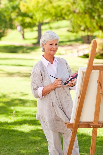 Pittura della donna senior nel parco