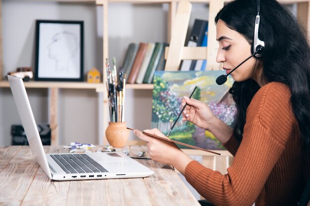 Pittura della giovane donna con l'istruzione in linea