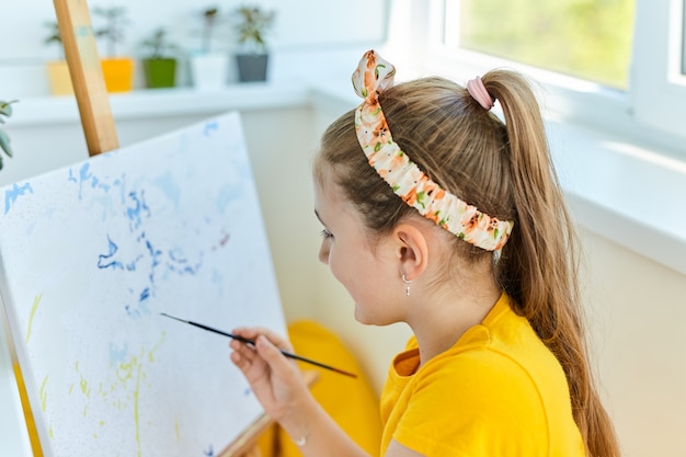 Pittura graziosa della bambina su tela. La creatività dei bambini.