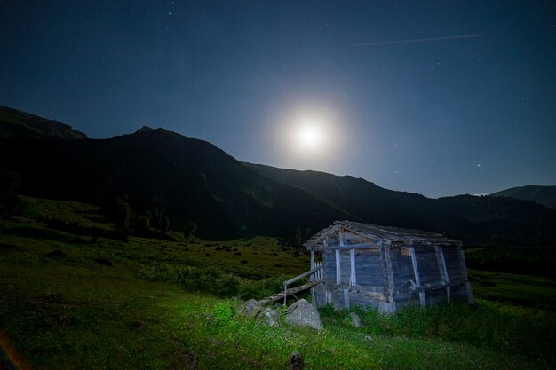 Pittura leggera creativa di una cabina di legno abbandonata in Artvin rurale, Turchia con il cielo di ora blu - vista grandangolare