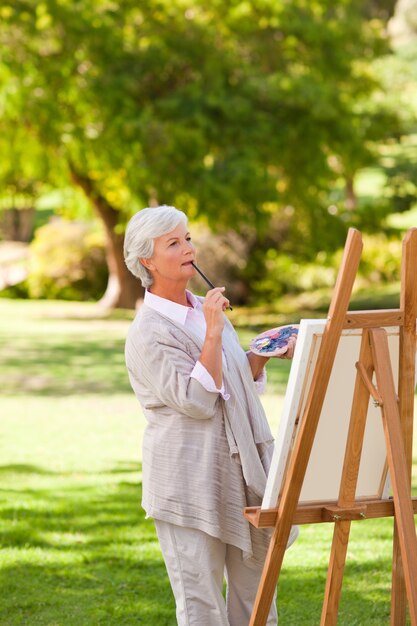 Pittura matura della donna nel parco