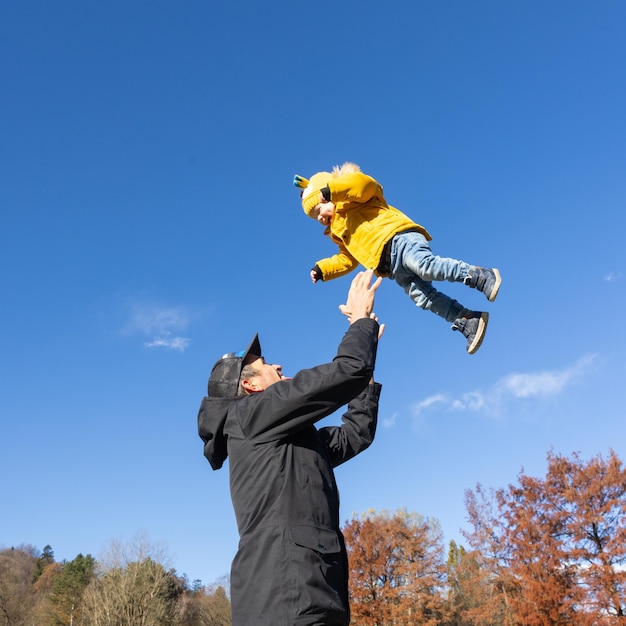 Più più papà che è divertente felice giovane padre lancia il suo bambino carino in aria giorno del padre