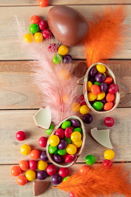 Piume colorate e dolci pasquali Uova di cioccolato per un regalo di festa