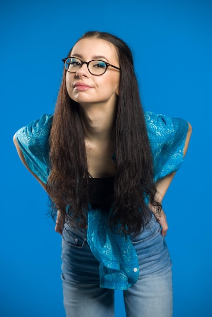 Piuttosto gioiosamente adolescente femmina con capelli castani vestita casualmente guardando la fotocamera bella bella