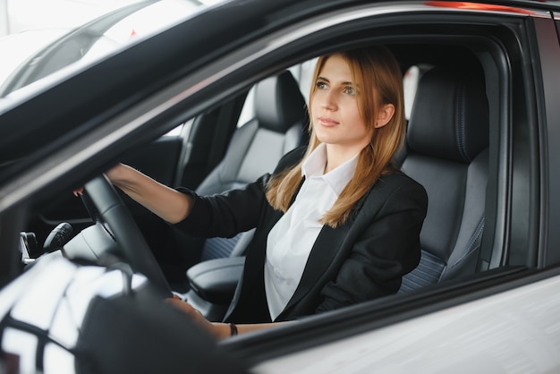 Piuttosto giovane donna alla guida della sua nuova auto (immagine dai toni di colore; DOF poco profondo)