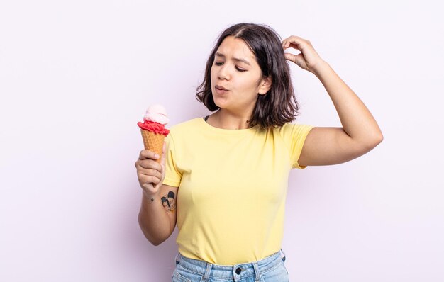 Piuttosto giovane donna sorridente felicemente e fantasticando o dubitando. concetto di gelato