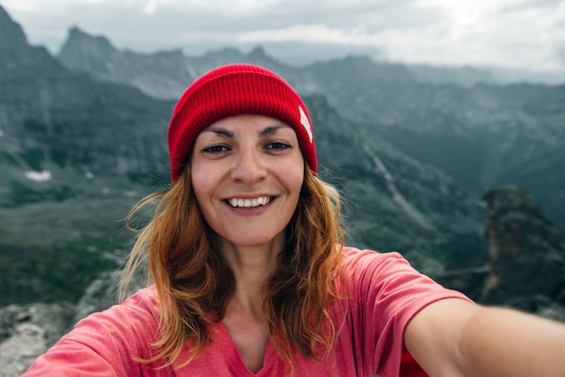 Piuttosto giovane turista femminile fa selfie in montagne Lifestyle concetto di avventura vacanze attive all'aperto